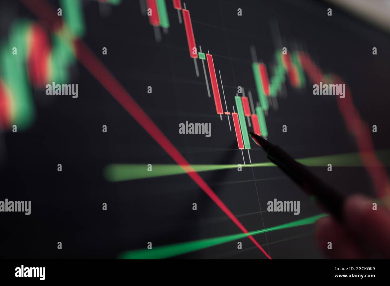 Crop unrecognizable broker pointing at display with binary option while working with graphics Stock Photo