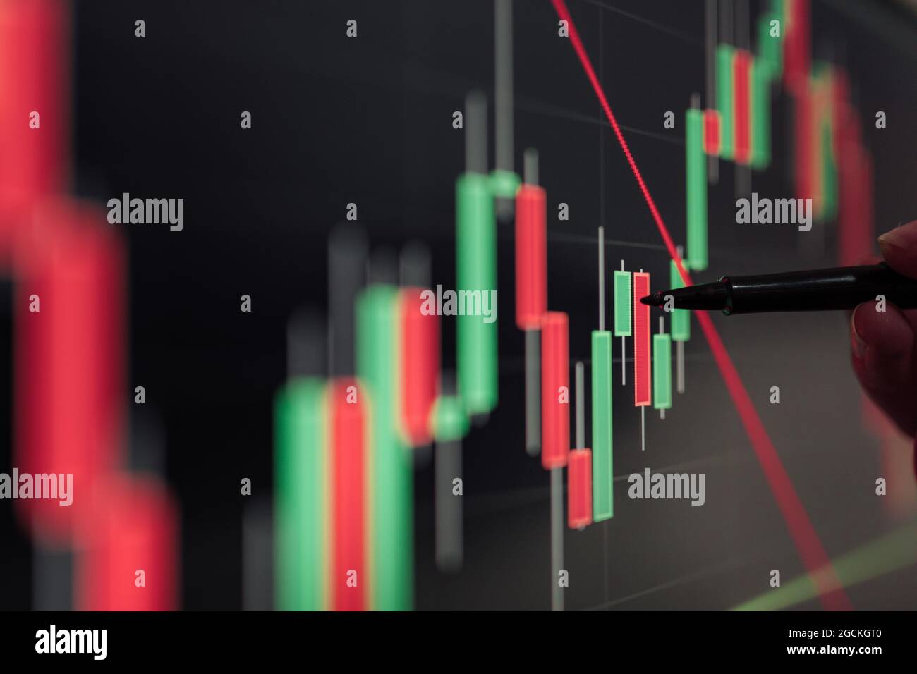 Crop unrecognizable broker pointing at display with binary option while working with graphics Stock Photo