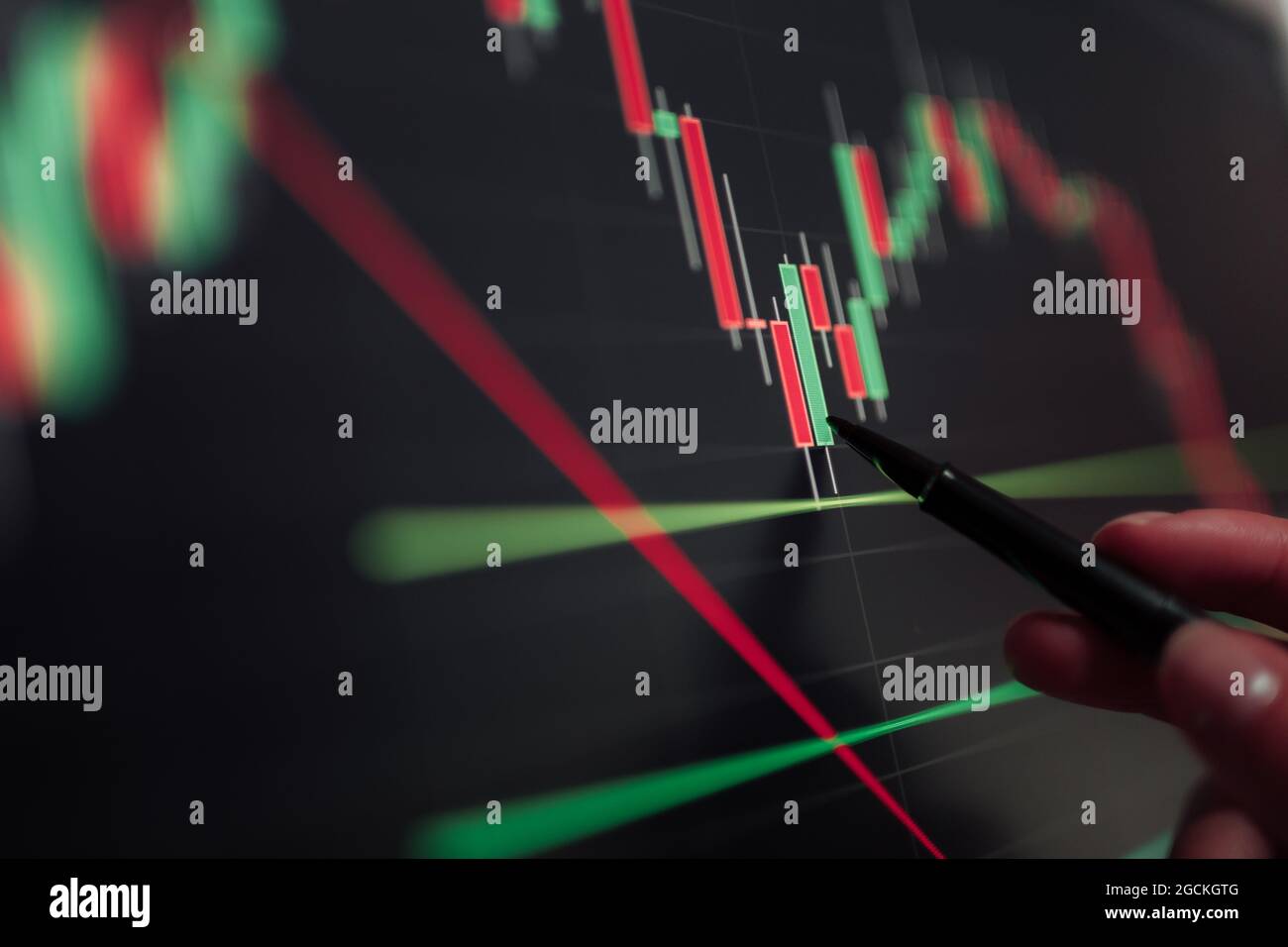 Crop unrecognizable broker pointing at display with binary option while working with graphics Stock Photo