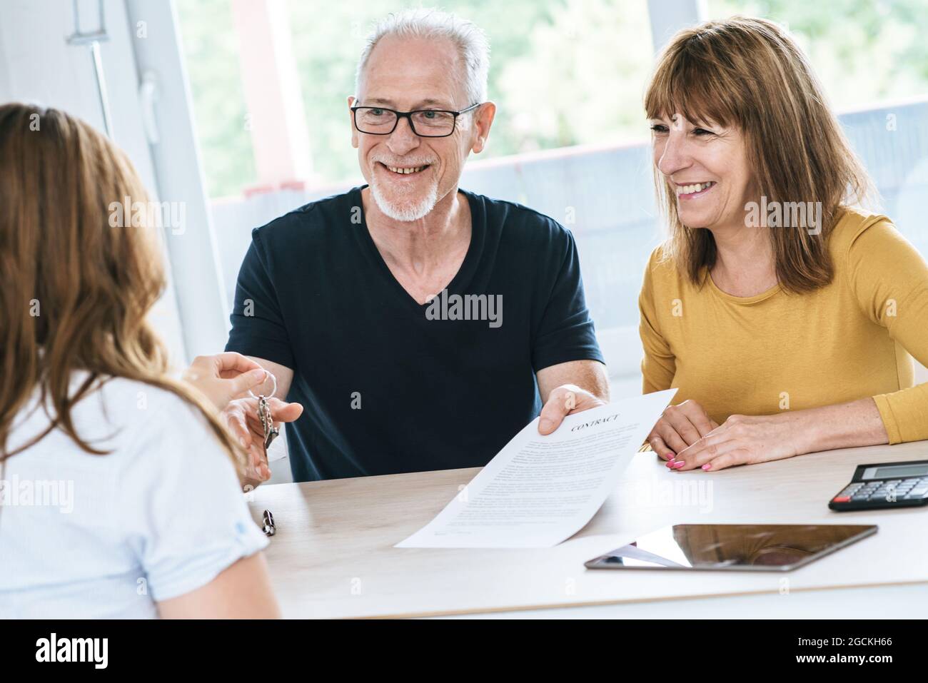 Real estate agent giving house keys to senior couple Stock Photo - Alamy