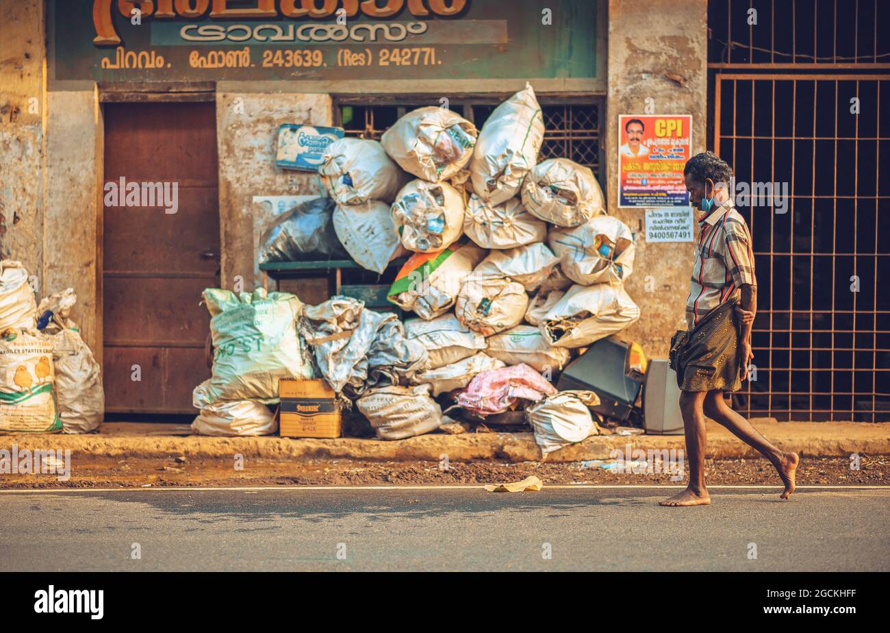 Man walking infront of a scrap shop Stock Photo