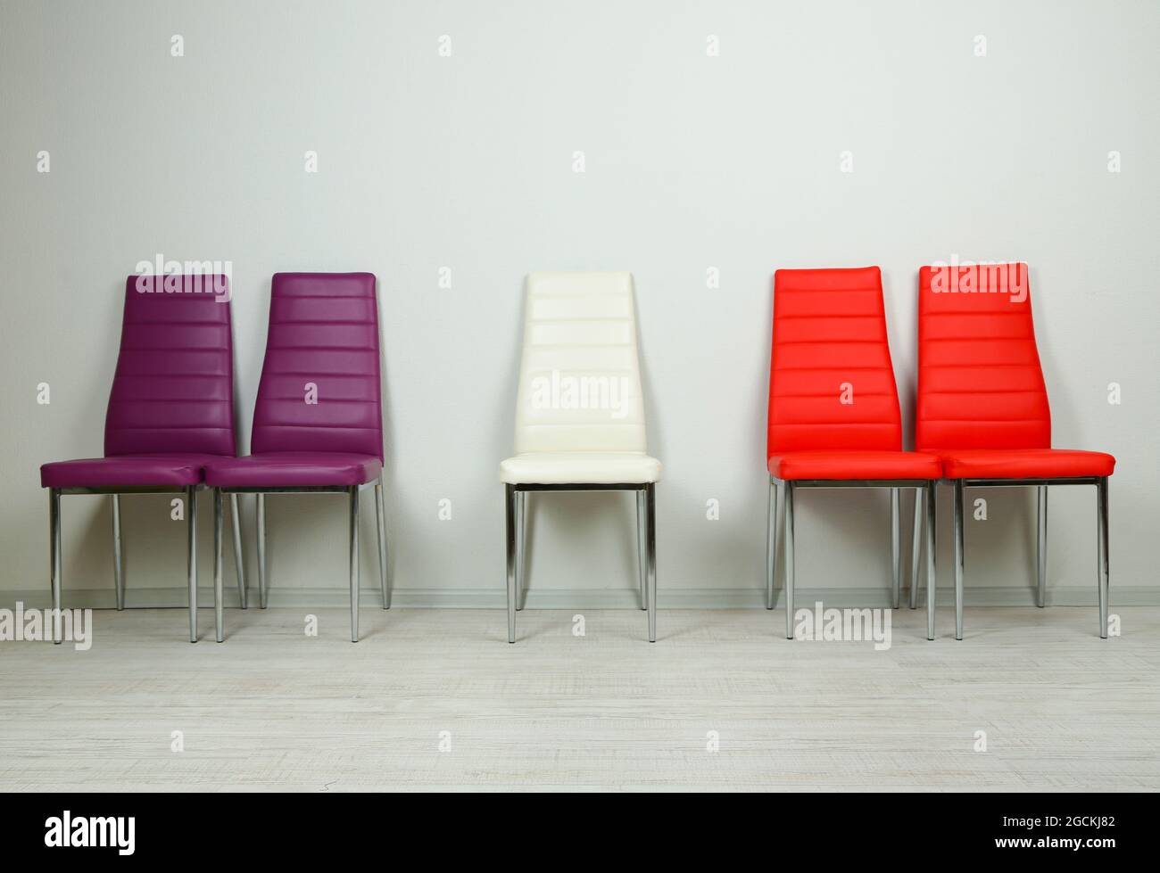 Modern color chairs on wall background Stock Photo Alamy