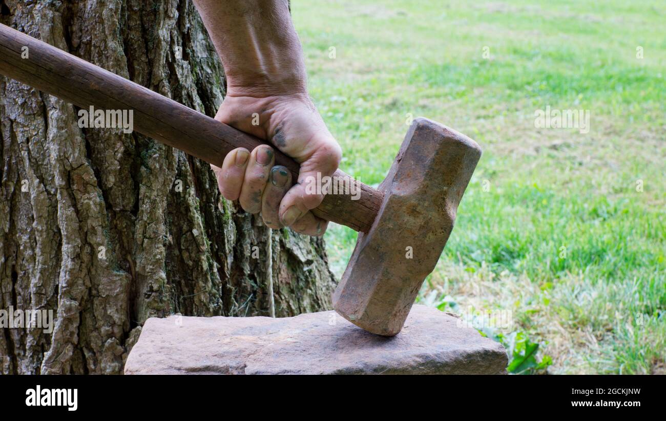 A Person Using a Sledge Hammer to Break up a Rock Stock Photo Alamy