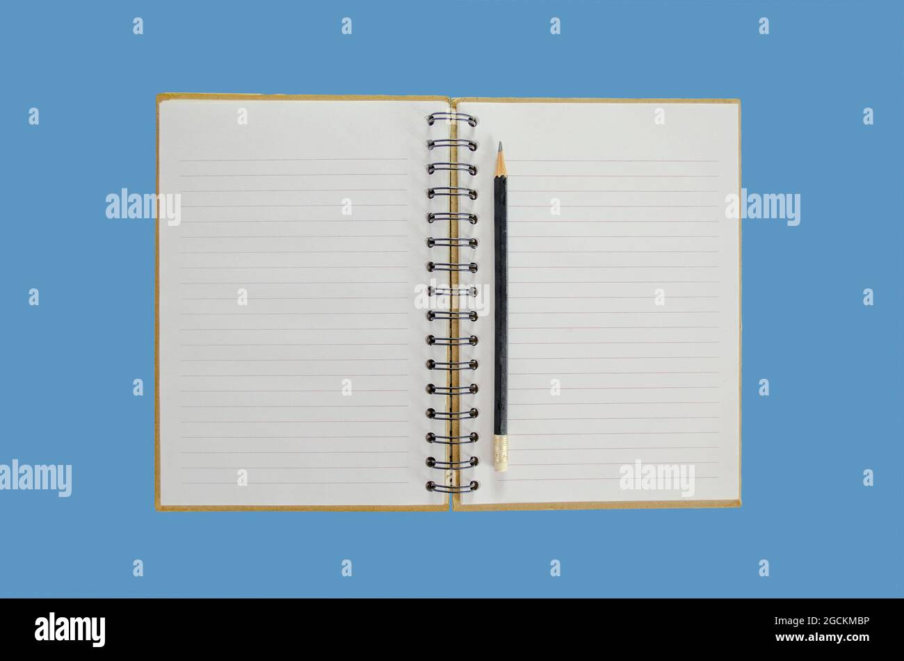 Opened notebook with a pencil on it with a blue background Stock Photo