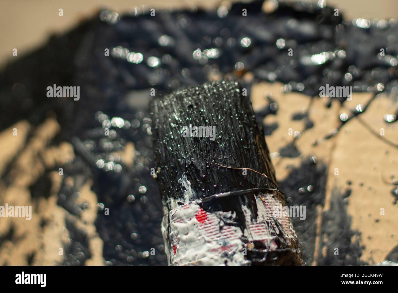 Brush with black paint. Painting with a brush. A lot of paint on the