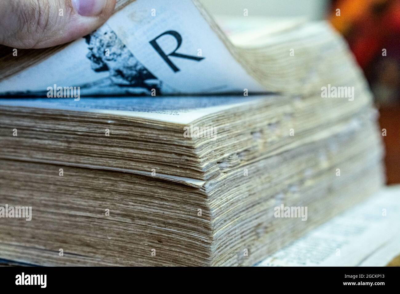 Man's hand opening an ancient script Stock Photo