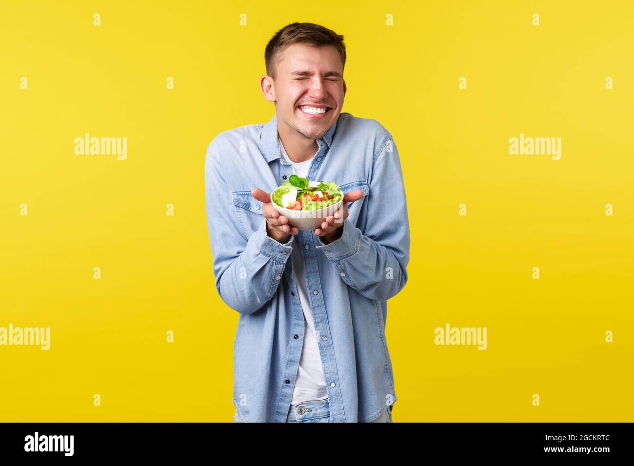 Healthy lifestyle, people and food concept. Excited, extremely happy handsome blond man smiling with closed eyes, rejoicing as prepared delicious Stock Photo