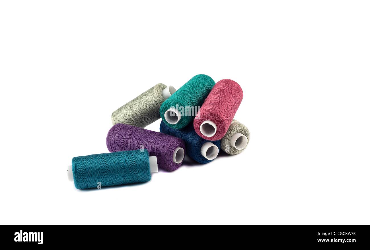 Bunch of spools with colored threads on a white background. Copy space. Stock Photo