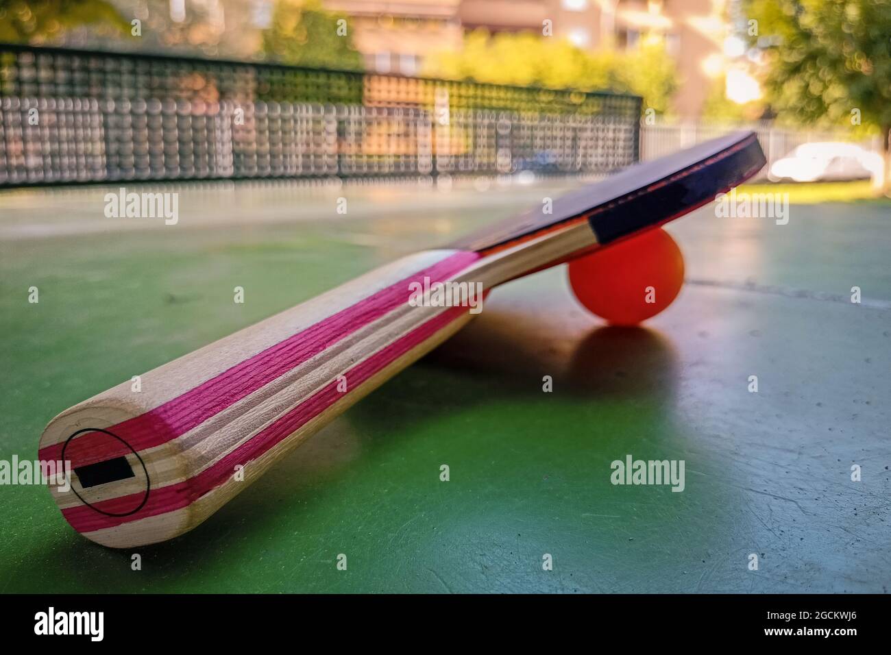 Ping-pong racket and ball on a tennis table in a public park. Concept of table tennis outdoors. Stock Photo