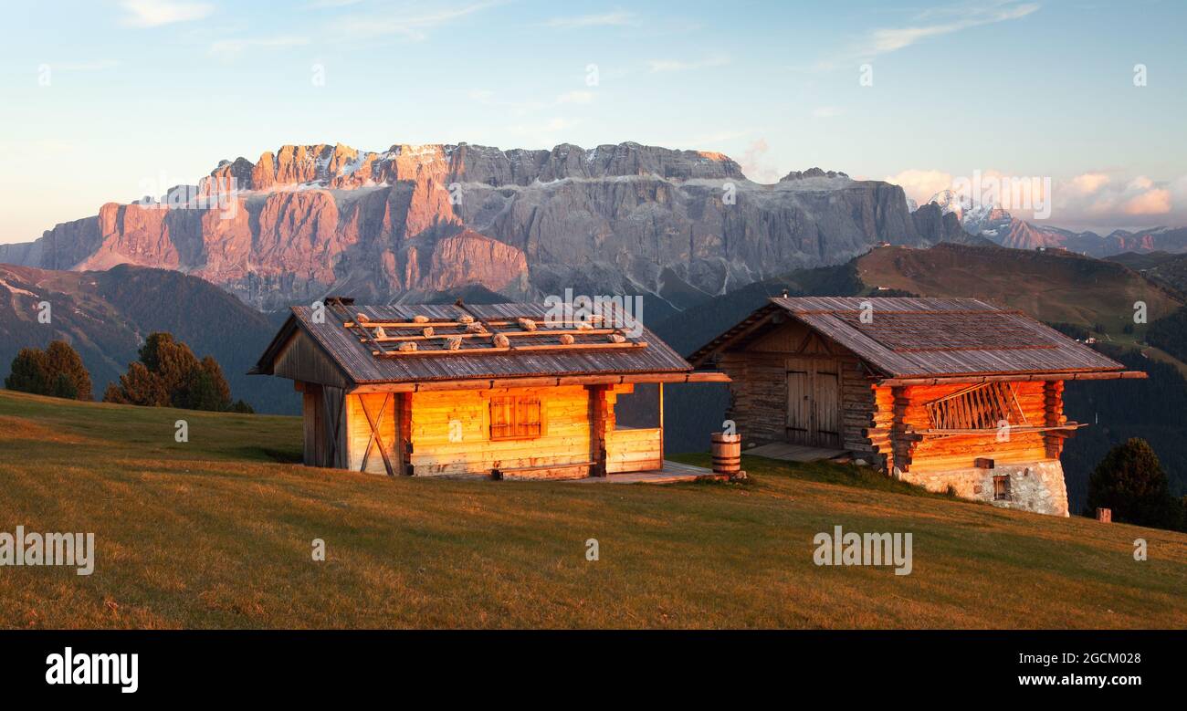 Evening view of two small cabin and Sella Gruppe or Gruppo di Sella