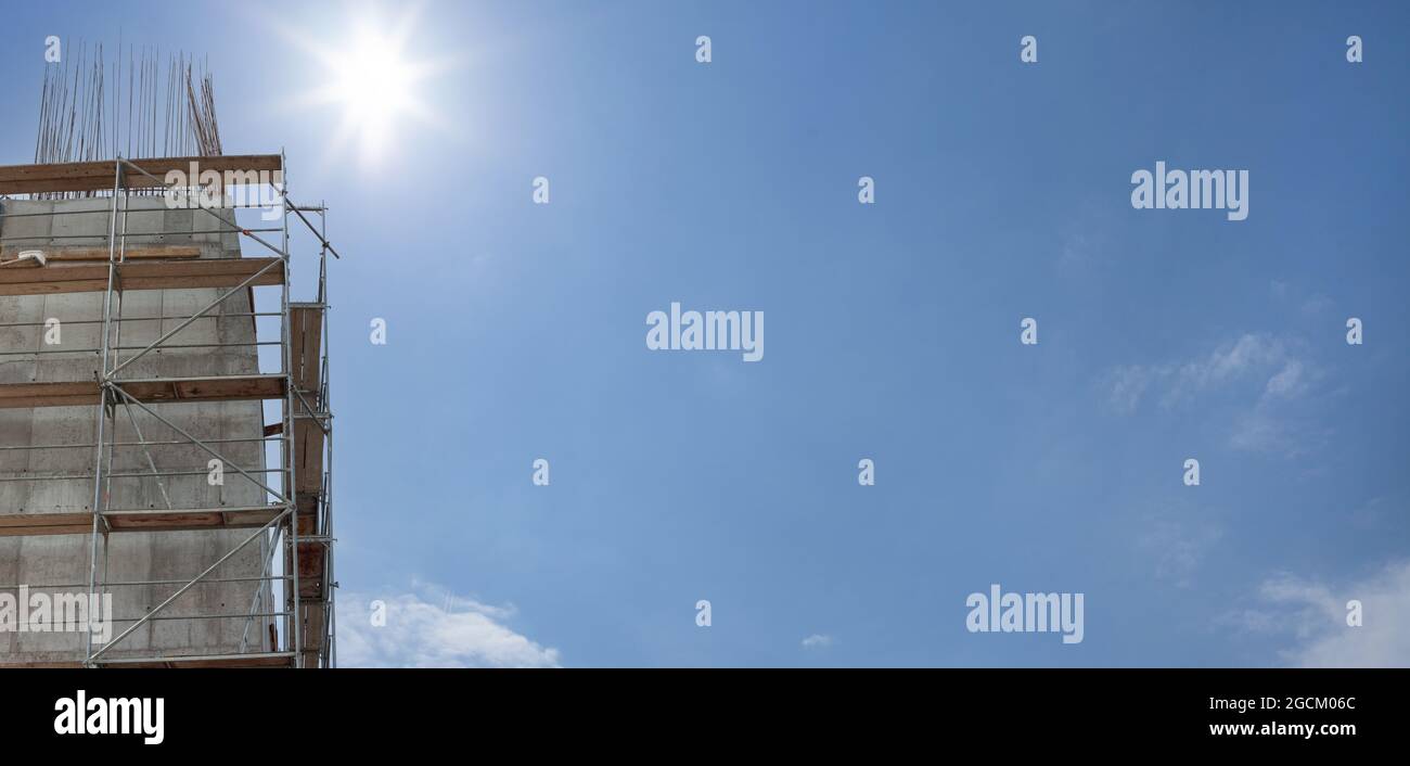 Scaffolding, metal mobile scaffold aginst blue sky background. Banner. Stock Photo