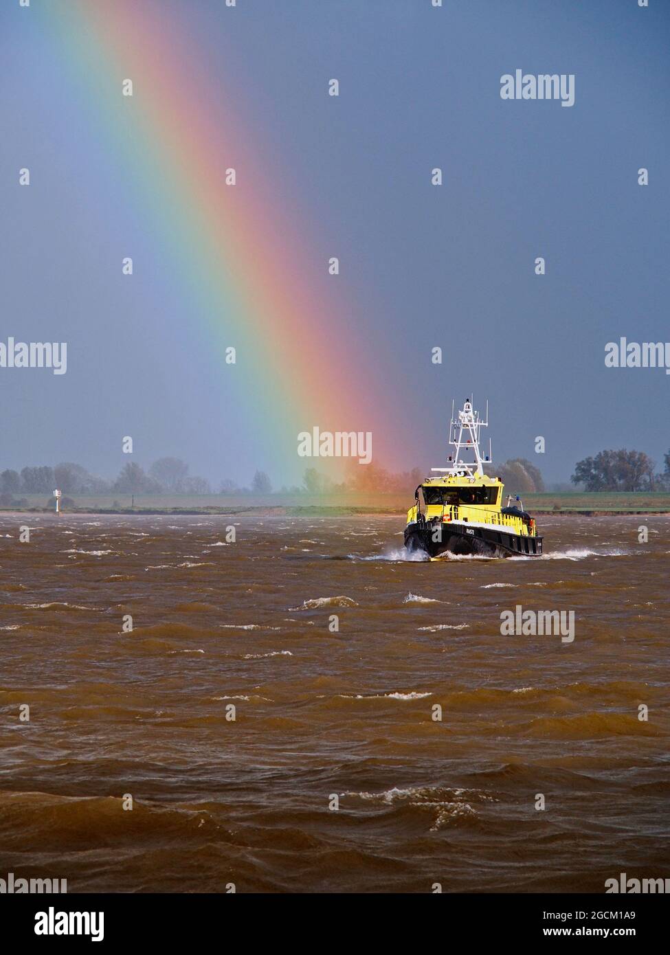 Rainbow ends at a yellow tugboat on the River Rhine Germany Stock Photo