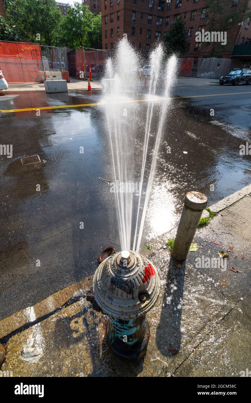 Splashing water from the Fire hydrant makes rainbow on the Street in