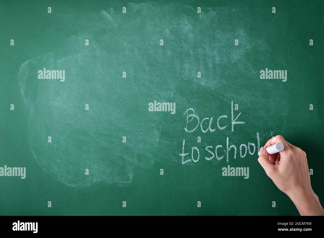 Female teachers hand writing on school board back to school white chalk. Concept back to school. Mock up for design. Copy space. Education Concept. Stock Photo