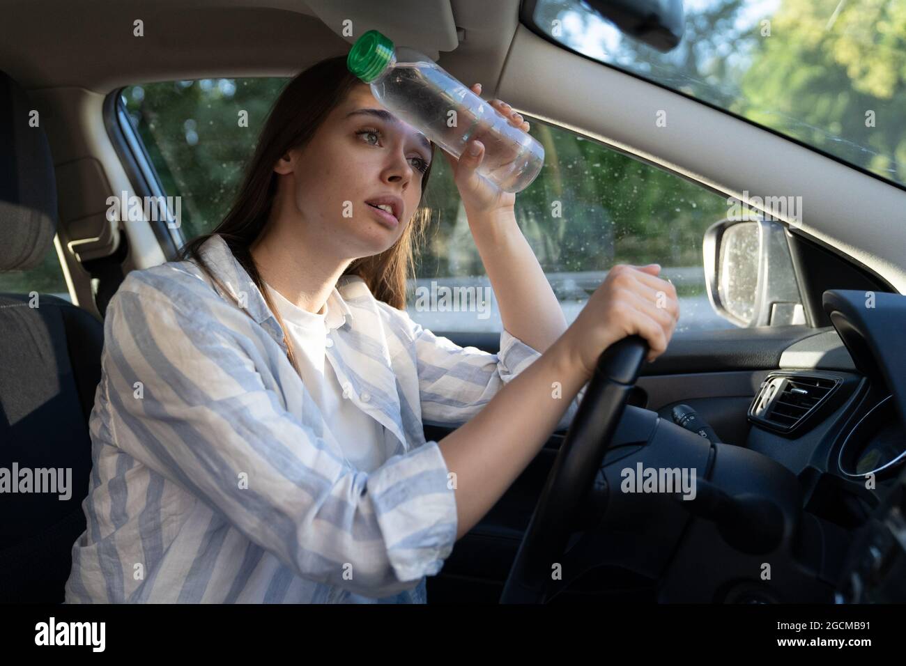 Exhausted girl driver suffering from headache, heat, hot weather