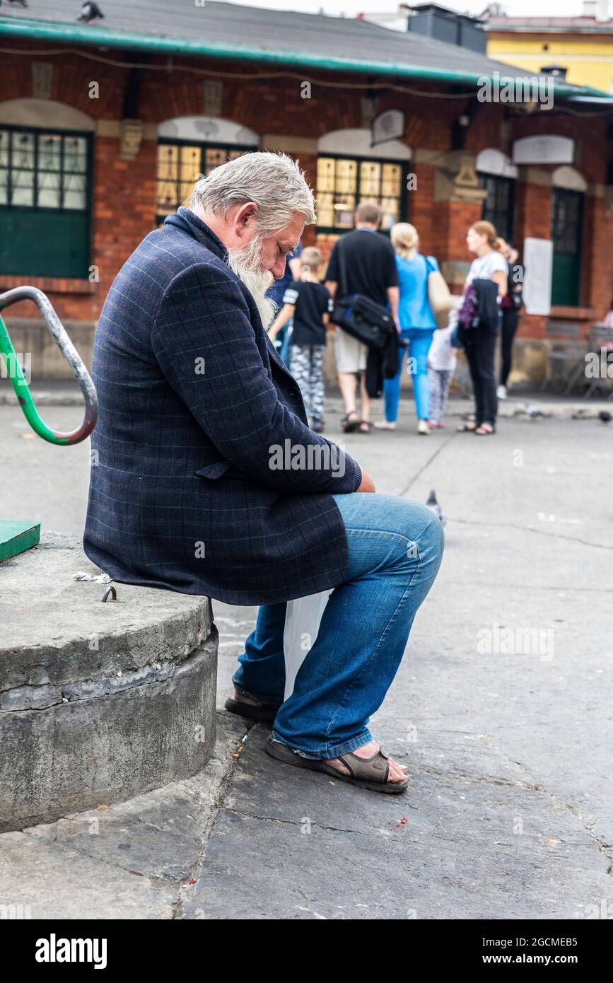 Krakow, Poland - August 28, 2018: Senior man with beard and mustache resting in the flea market of the Plac Nowy in Krakow, Poland Stock Photo