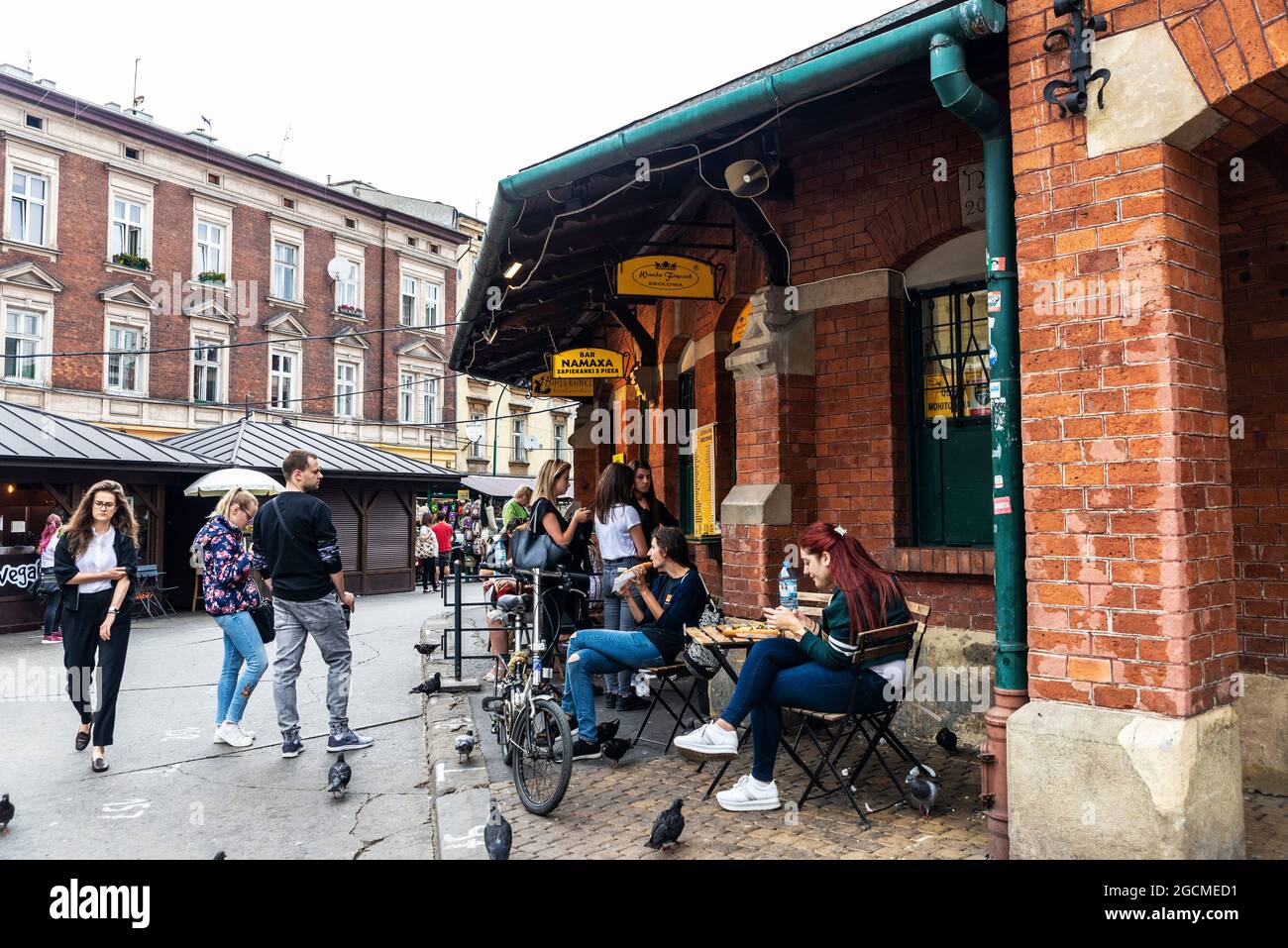 Krakow, Poland - August 28, 2018: People in a bar eating the traditional zapiekanka, a baguette with various toppings in the flea market of the Plac N Stock Photo
