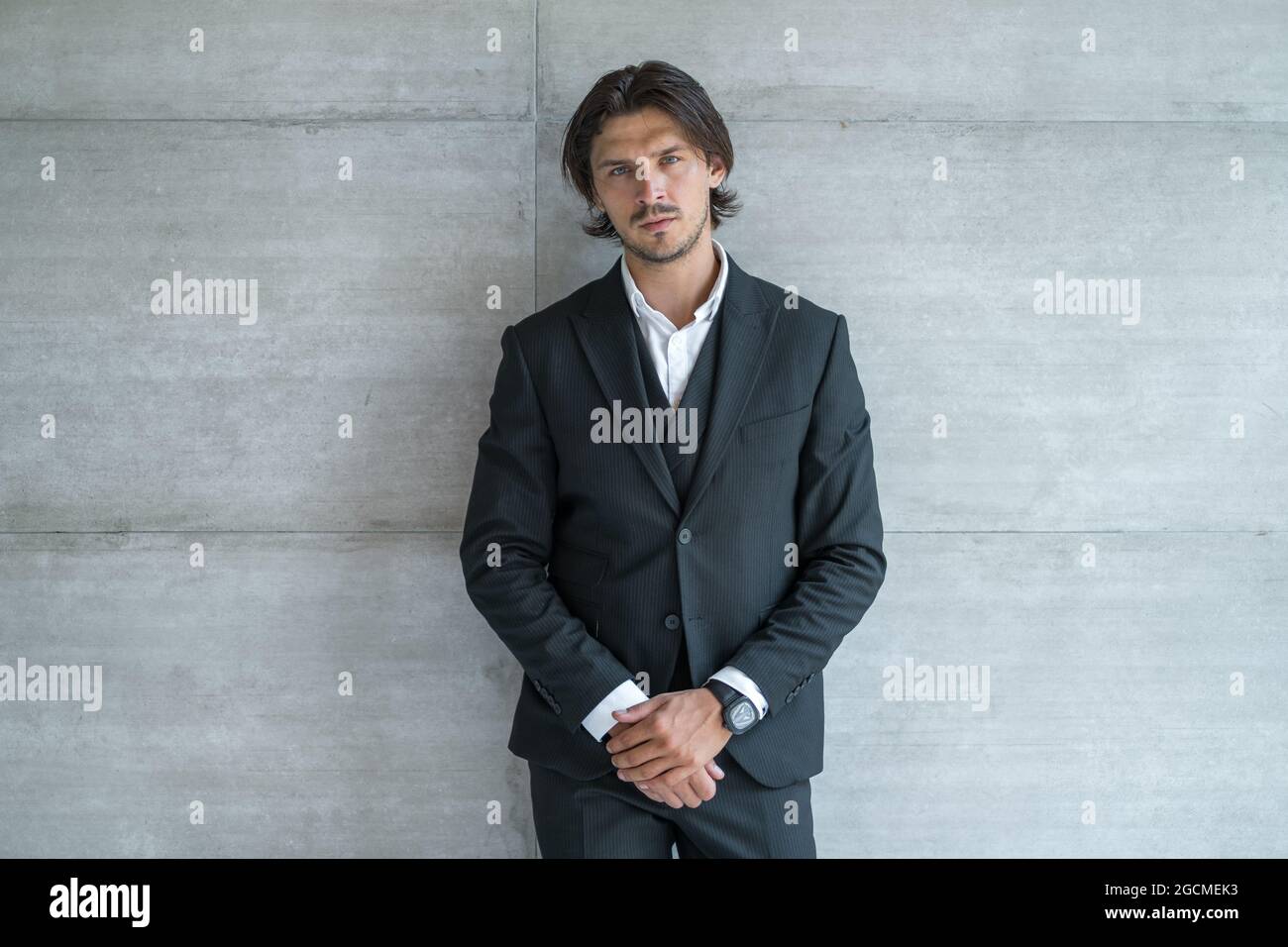 Portrait of handsome young business man wearing black classic suit ...