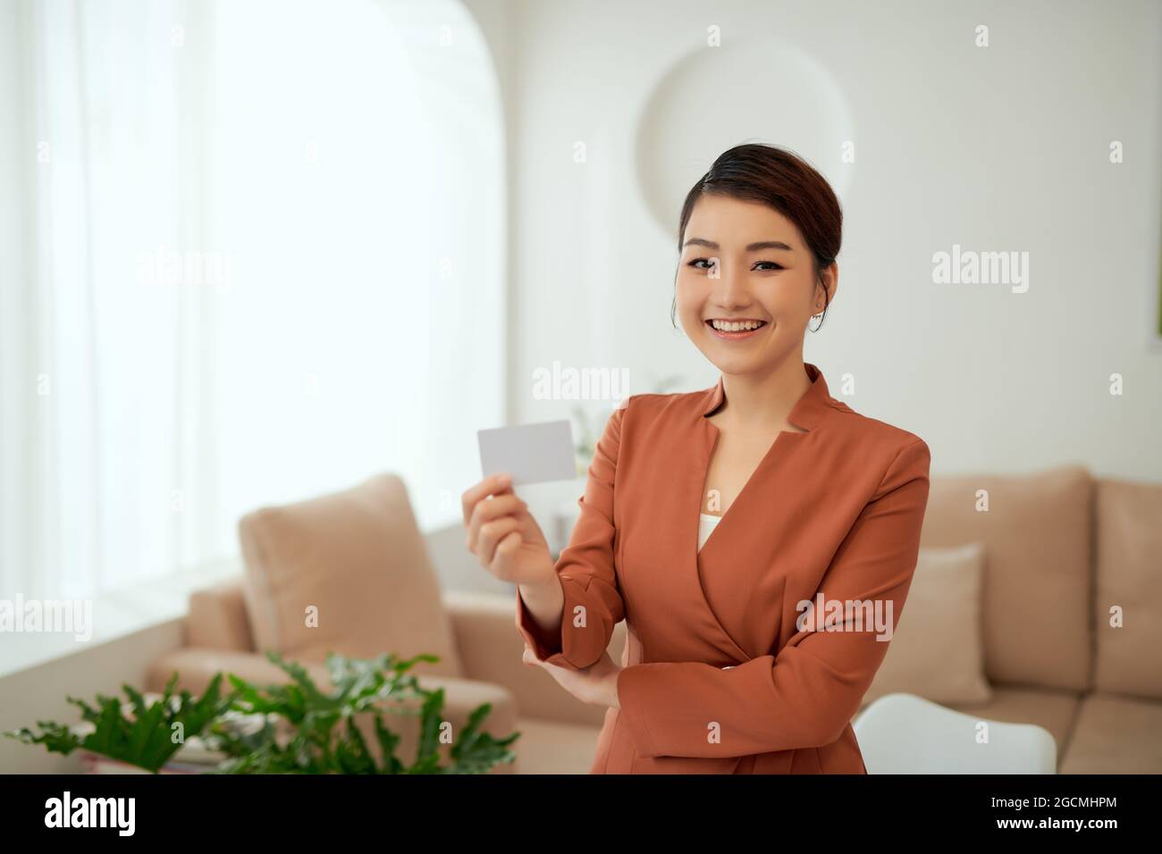 Portrait of businesswoman holding name card while stand in office room Stock Photo