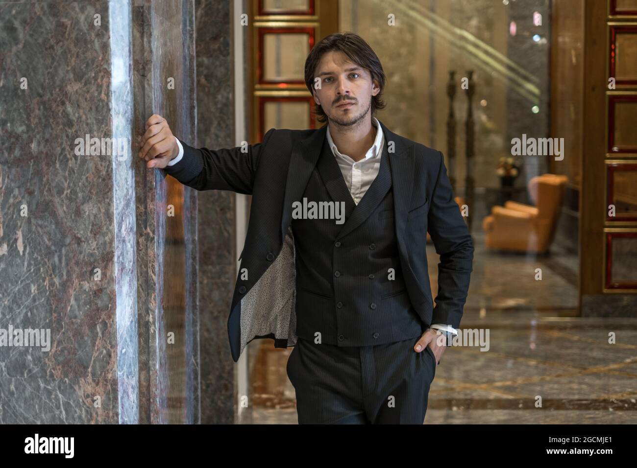 Portrait of handsome young businessman wearing black classic suit ...