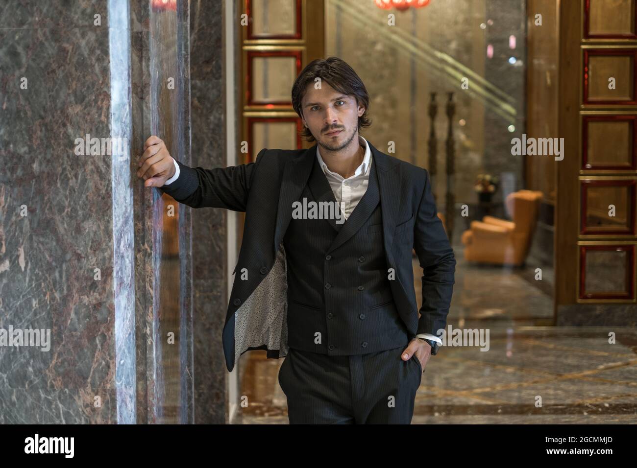 Portrait of handsome young businessman wearing black classic suit ...