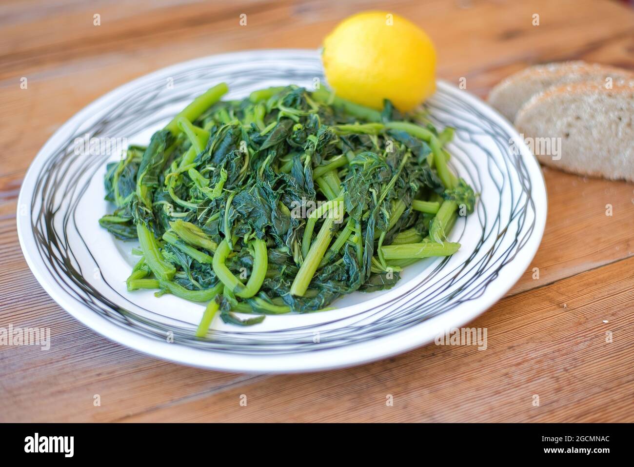 Amaranthus blitum . Vlita Salad on a plate, on a wooden old table Stock Photo