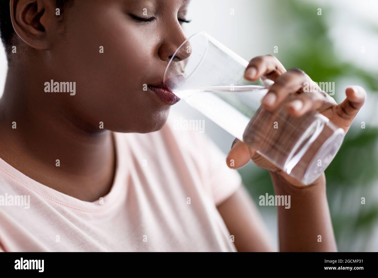 Keep hydrated for healthier living. Overweight black woman drinking