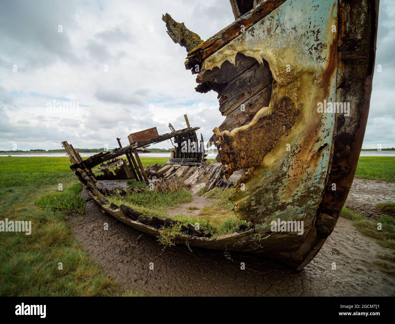 closeup of rusty and fire damaged fishing boat abandoned on the shore