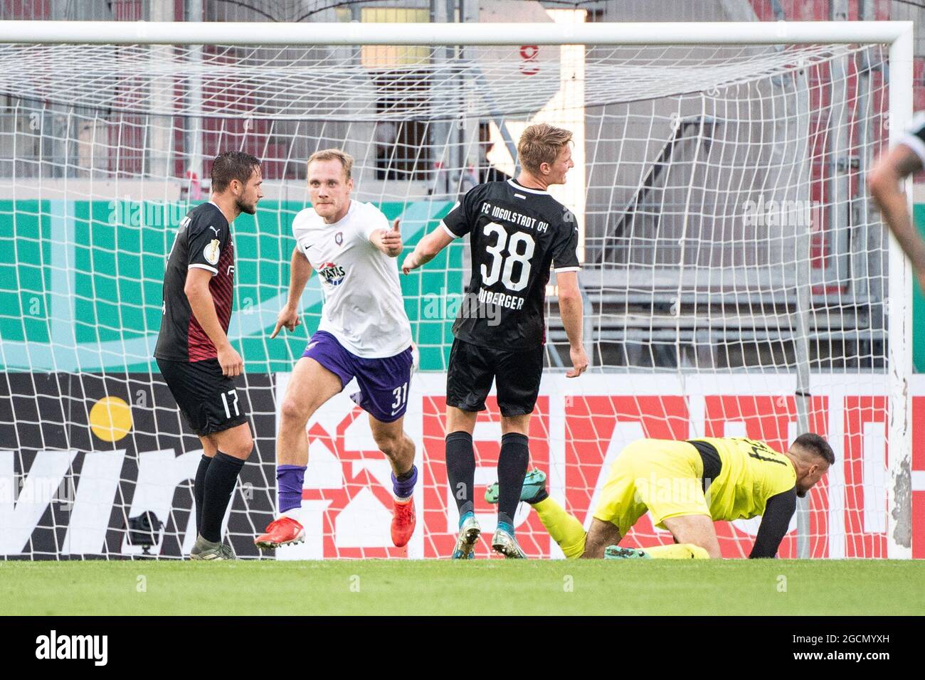 09 August 2021, Bavaria, Ingolstadt: Football: DFB Cup, FC Ingolstadt 04 - Erzgebirge Aue, 1st round at Audi Sportpark. Ben Zolinski of Erzgebirge Aue (2nd from left) celebrates his goal to make it 1:1, while goalkeeper Fabijan Buntic of Ingolstadt (r) kneels behind him. Next to him are Michael Heinloth (l) and Maximilian Neuberger (2nd from right) of Ingolstadt. (Important note: The DFB prohibits the use of sequence pictures on the internet and in online media during the match (including half-time). Restriction period! The DFB allows the publication and further use of the images on mobile dev Stock Photo