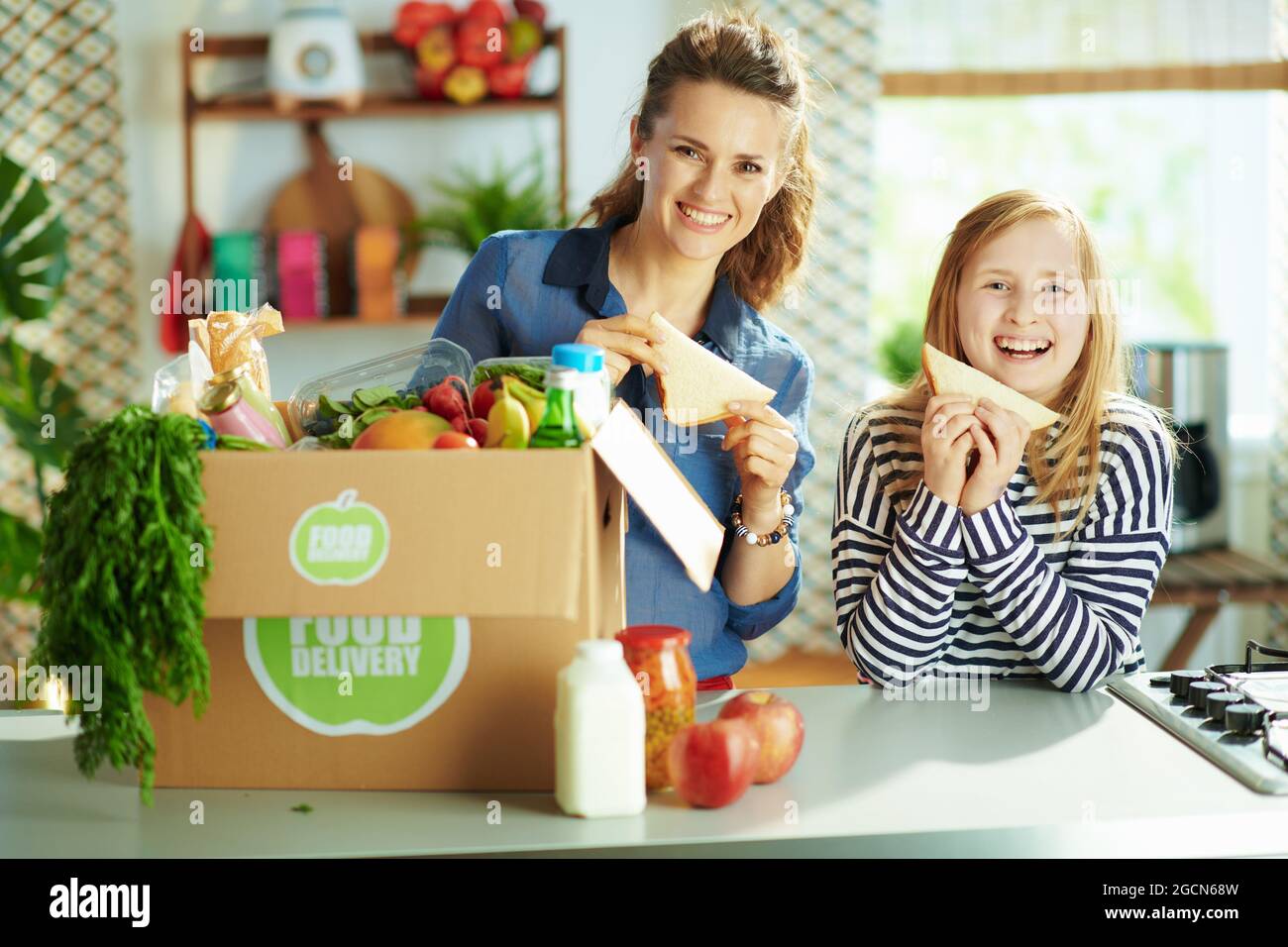 Food delivery. happy young mother and daughter with food box and