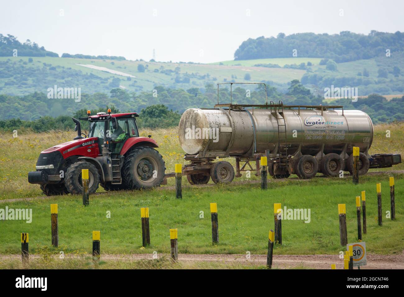 Case Puma 340 red tractor towing a 30,000 litre water trailer Stock Photo
