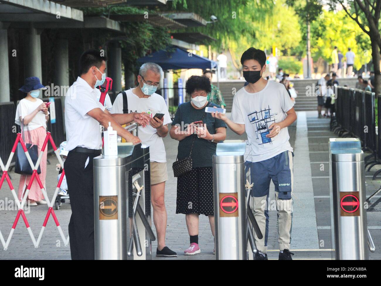 Staff check people's green health codes at the gate of the entrance in a park in Shanghai, China