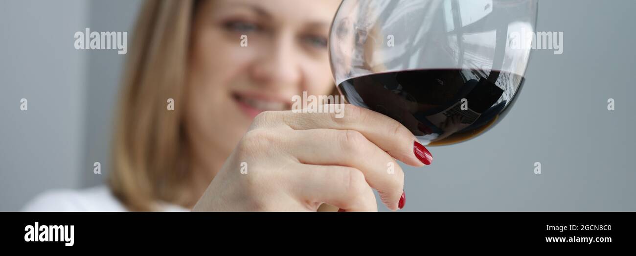 Woman holds glass of red wine in her hand Stock Photo - Alamy