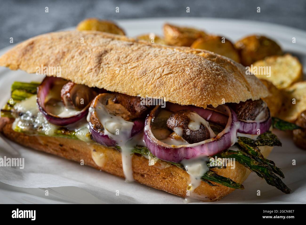 Grilled vegetables on hoagie bread with roasted potatoes. Stock Photo