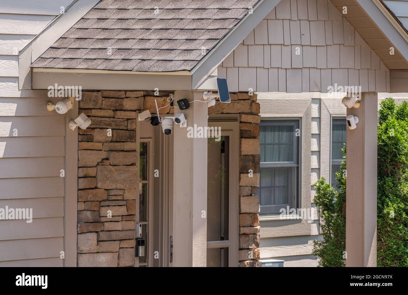 Modern entrance door of home surrounded by security video cameras and sensors for protection against burglary Stock Photo