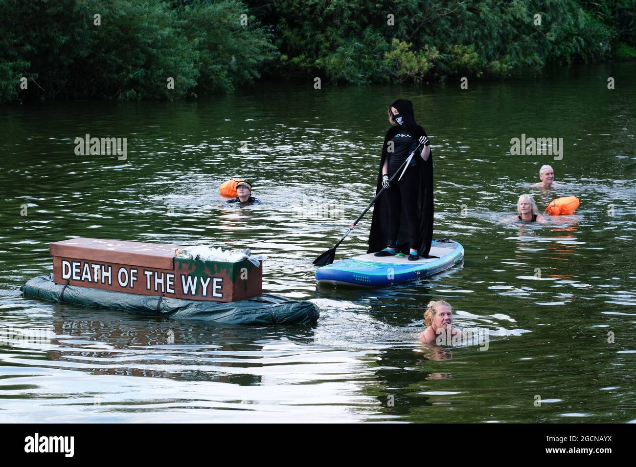 Ross on Wye, Herefordshire, UK – Monday 9th August 2021 – Wild swimming coach Angela Jones leads a protest with a mock coffin marked “Death of the Wye” about the high levels of pollution and sewage in the River Wye. The River Wye has high levels of nitrates and phosphates which protesters say comes from the many intensive poultry farms along the route of the Wye as it passes through the counties of Powys and Herefordshire. Photo Steven May / Alamy Live News Stock Photo