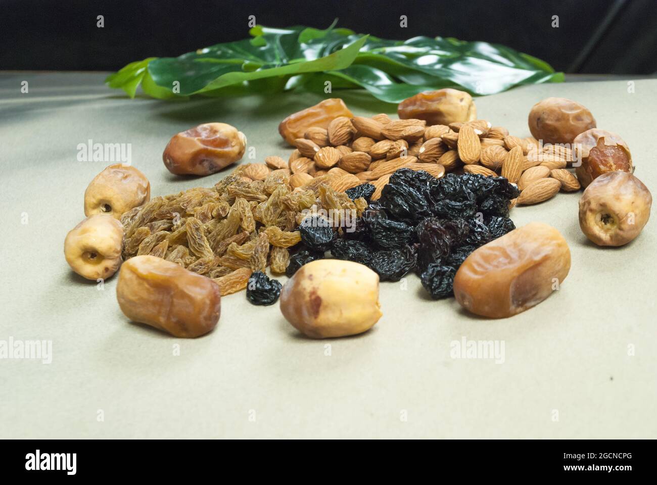 mix dry fruits nuts around dates isolated almonds black and brown raisins(kishmish) Stock Photo