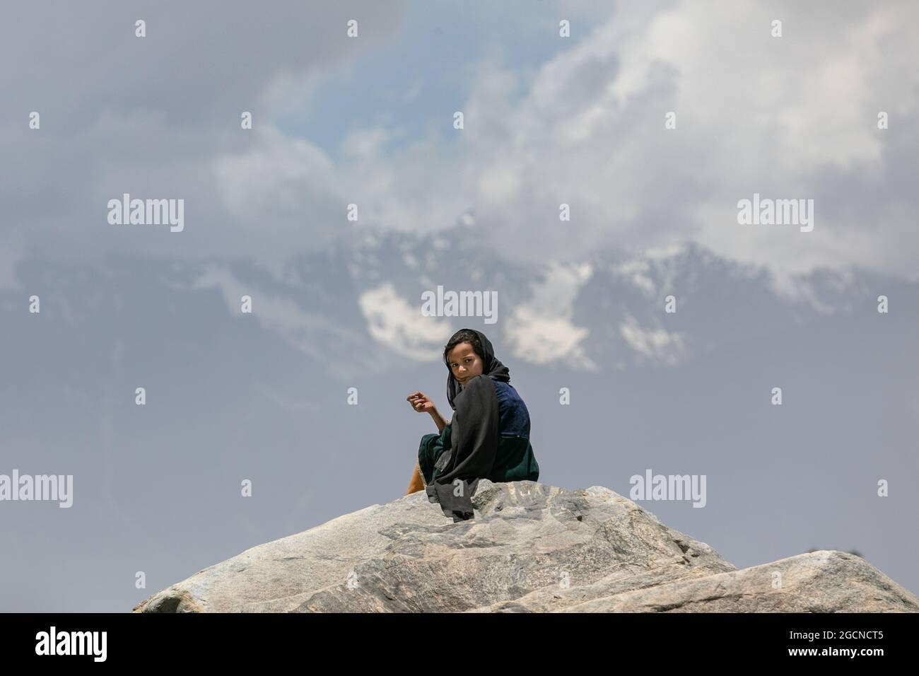 Gilgit-Baltistan, Pakistan - June 2021: Girl in black clothes in mountains  Stock Photo