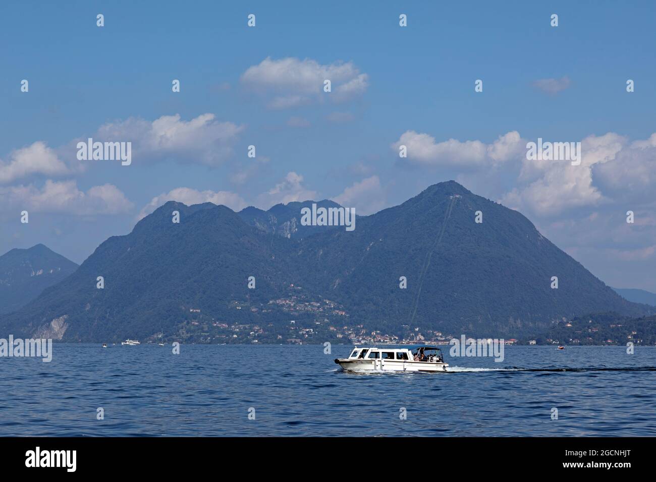 boat passing Monte Sasso del Ferro, Lake Maggiore, Lombardy, Italy Stock Photo