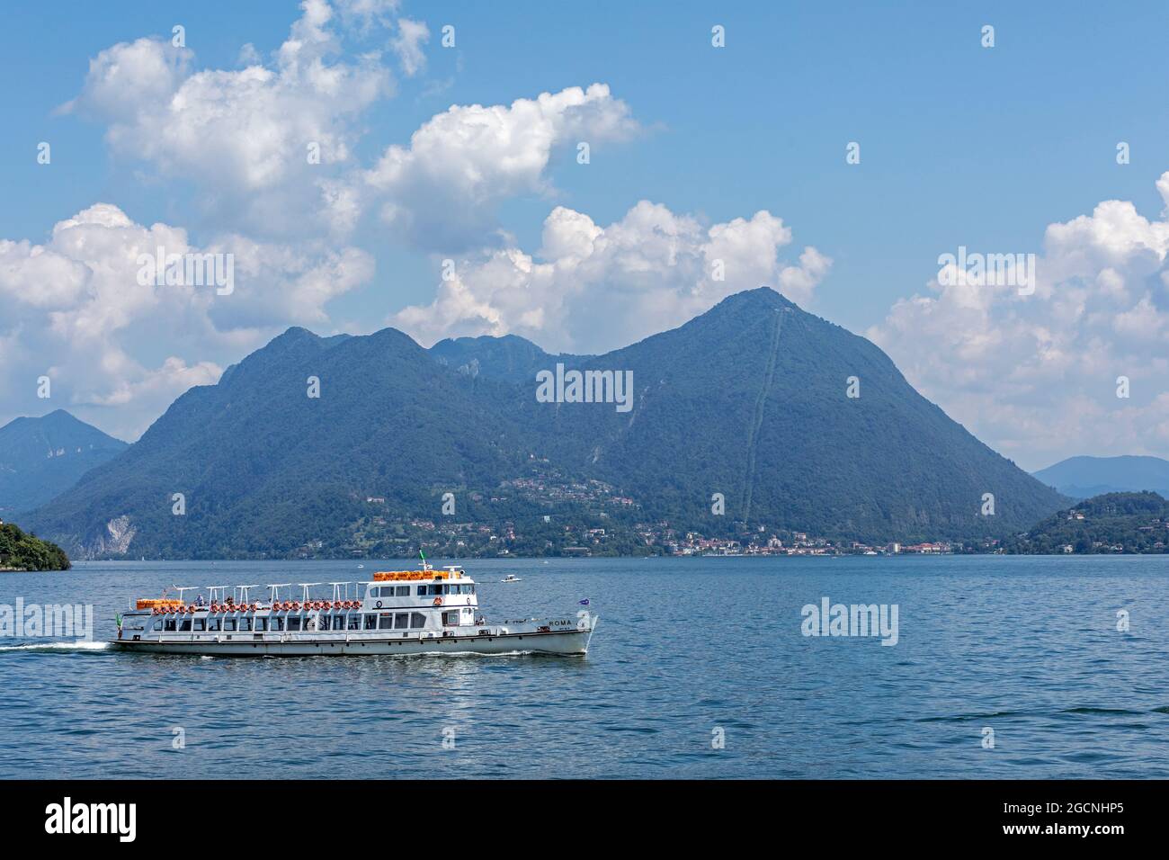 excursion boat passing Monte Sasso del Ferro, Lake Maggiore, Lombardy, Italy Stock Photo