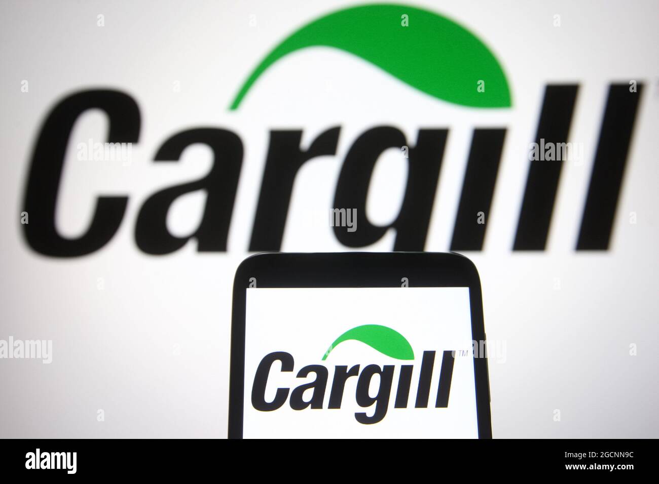 In this photo illustration a Cargill logo is seen on a smartphone and a