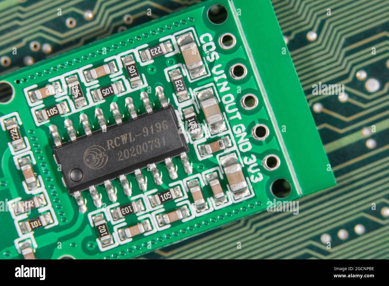 Macro close-up IC chip on small motion sensor circuit board pcb. Focus on RCWL-0516 lettering. Chip is a transmission signal processing control chip. Stock Photo