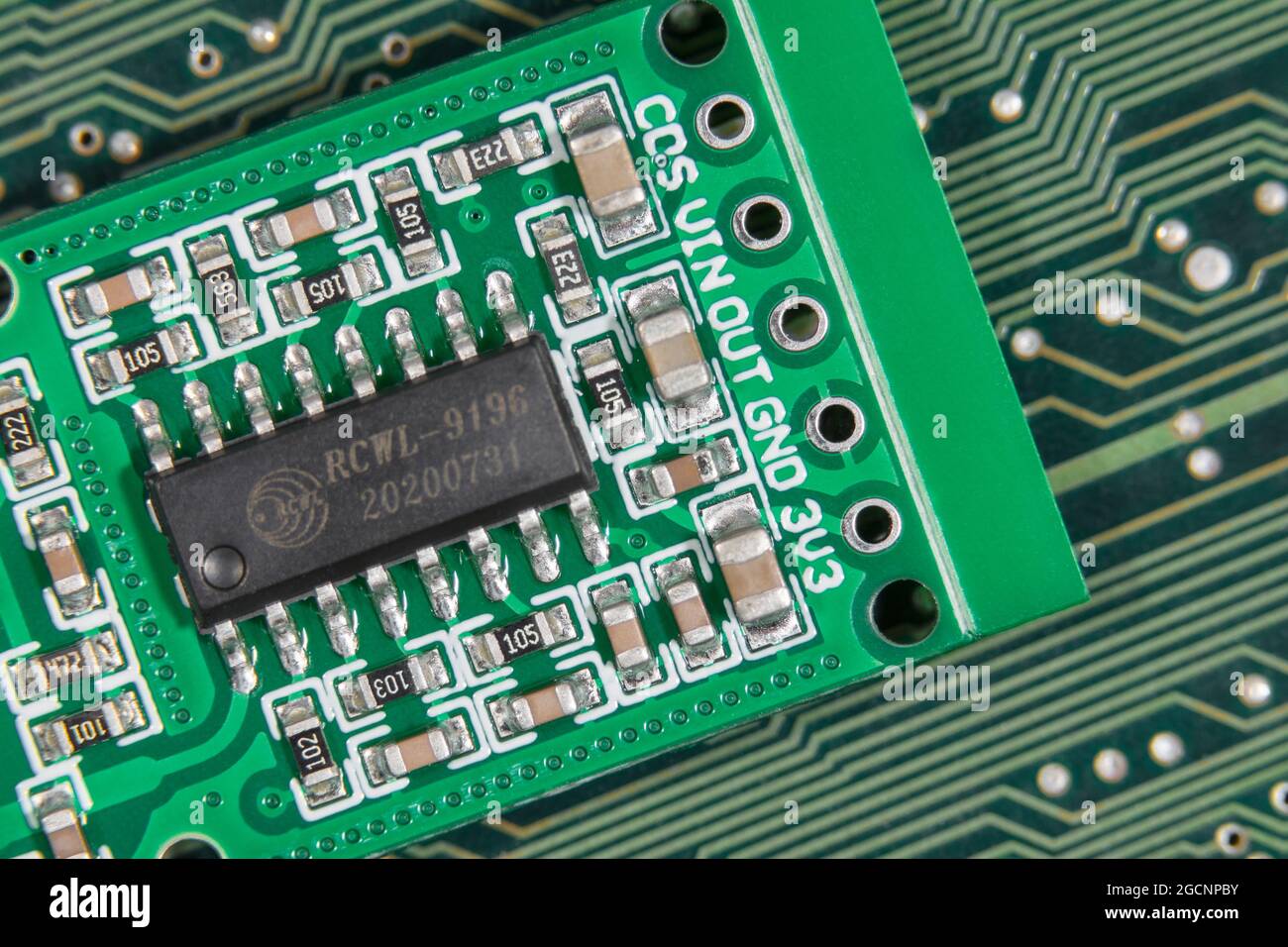 Macro close-up IC chip on small motion sensor circuit board pcb. Focus on lower components. Chip is a transmission signal processing control chip. Stock Photo