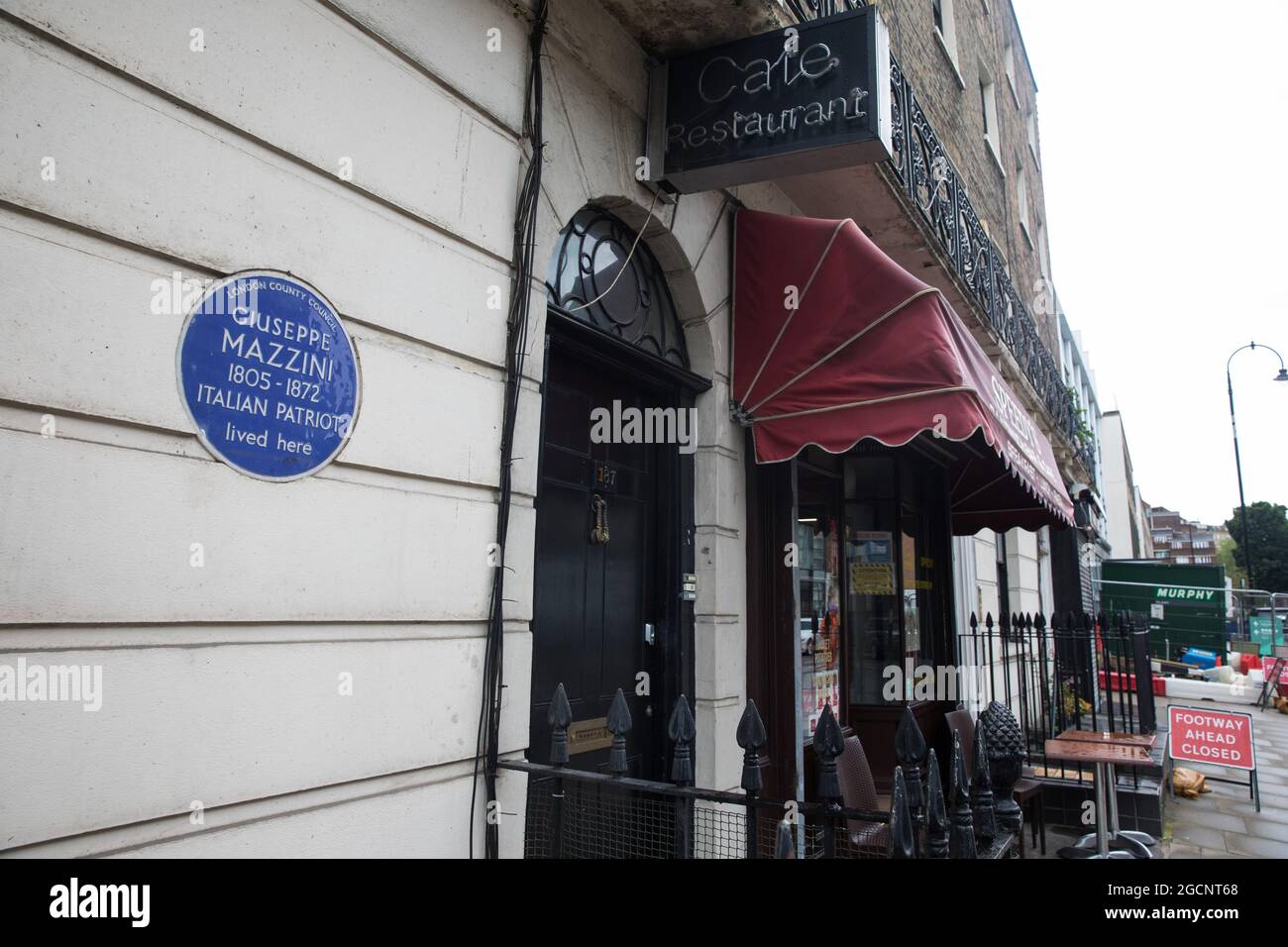 London, UK. 5th August, 2021. A blue plaque bearing Giuseppe Mazzini's name is pictured alongside Speedy's Sandwich Bar and Cafe. The ceramic plaque was installed in honour of the Italian patriot by London County Council in 1950. Credit: Mark Kerrison/Alamy Live News Stock Photo