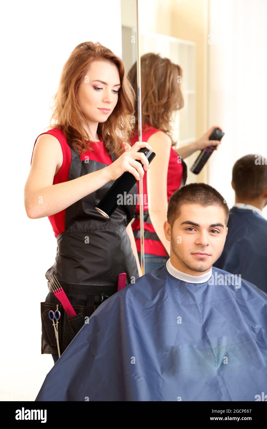 Beautiful girl hairdresser do hairstyle guy in beauty salon Stock Photo ...