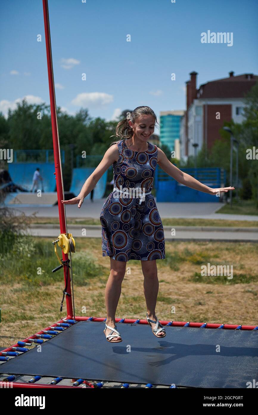 adult girl jumping on a trampoline in summer Stock Photo Alamy