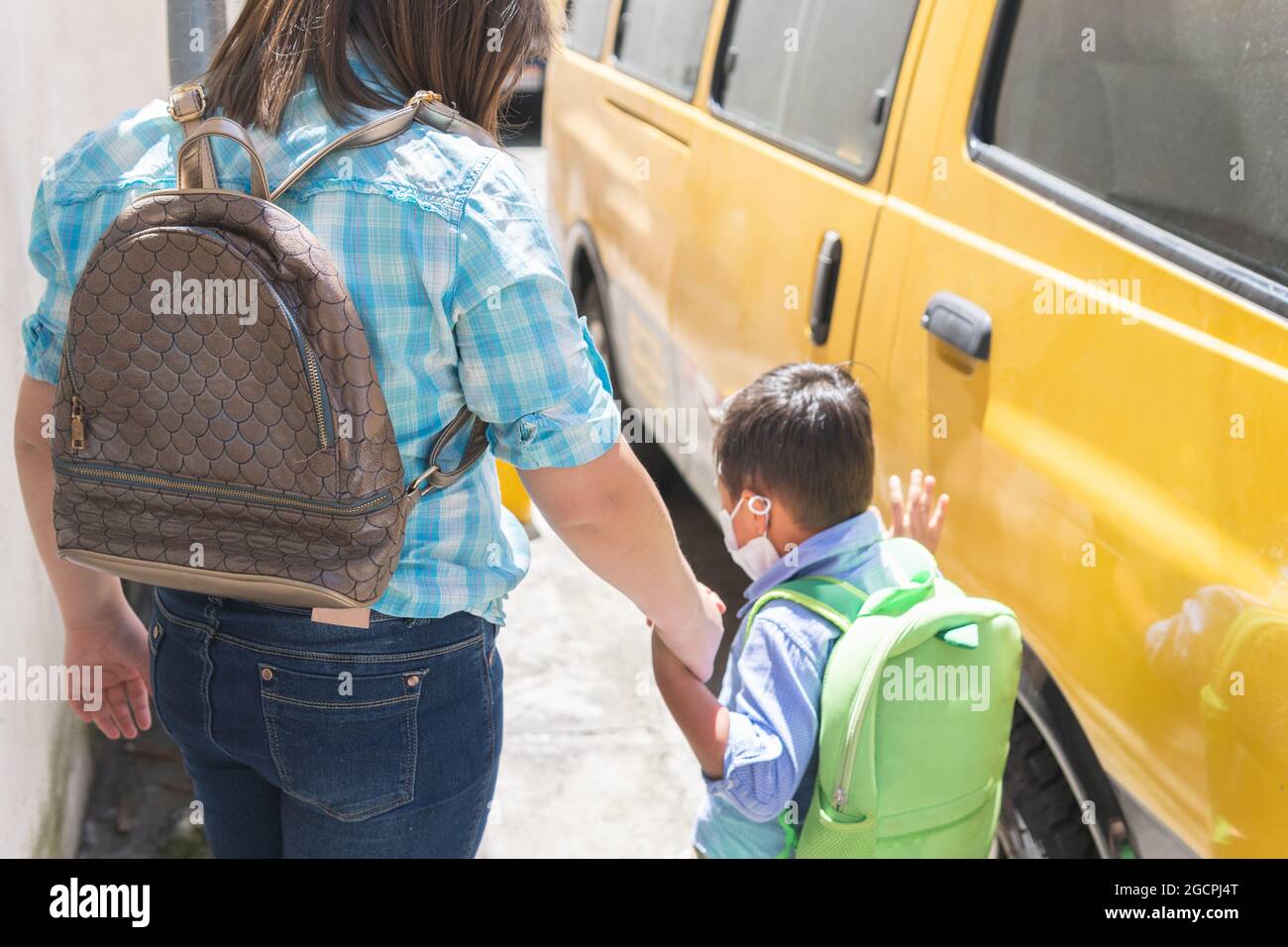 Brother and sister getting on the school bus. Back to school Stock Photo