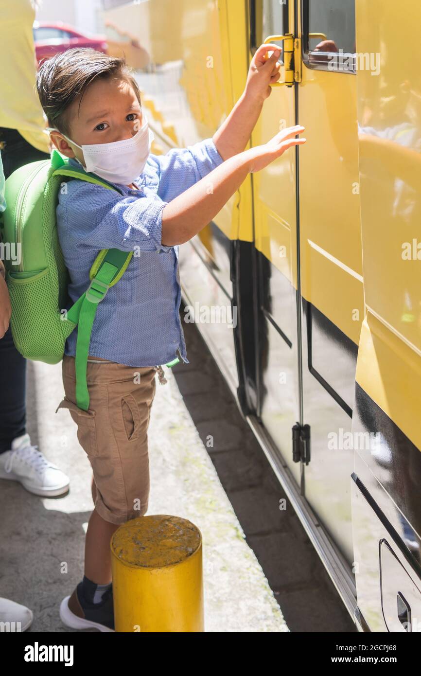 preschool boy getting on the school bus Stock Photo