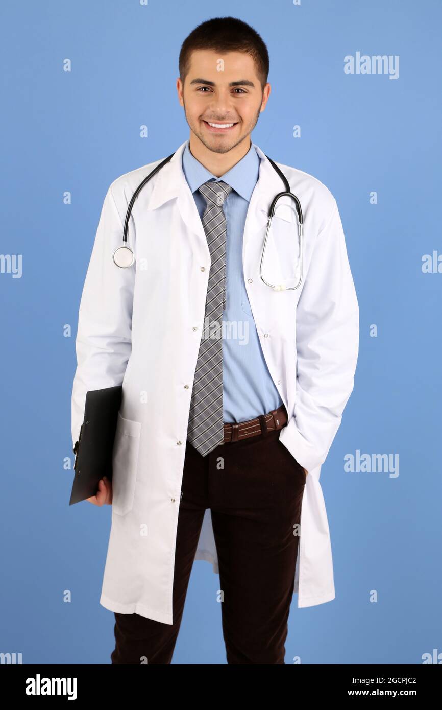 Male Doctor standing with folder, on blue background Stock Photo - Alamy