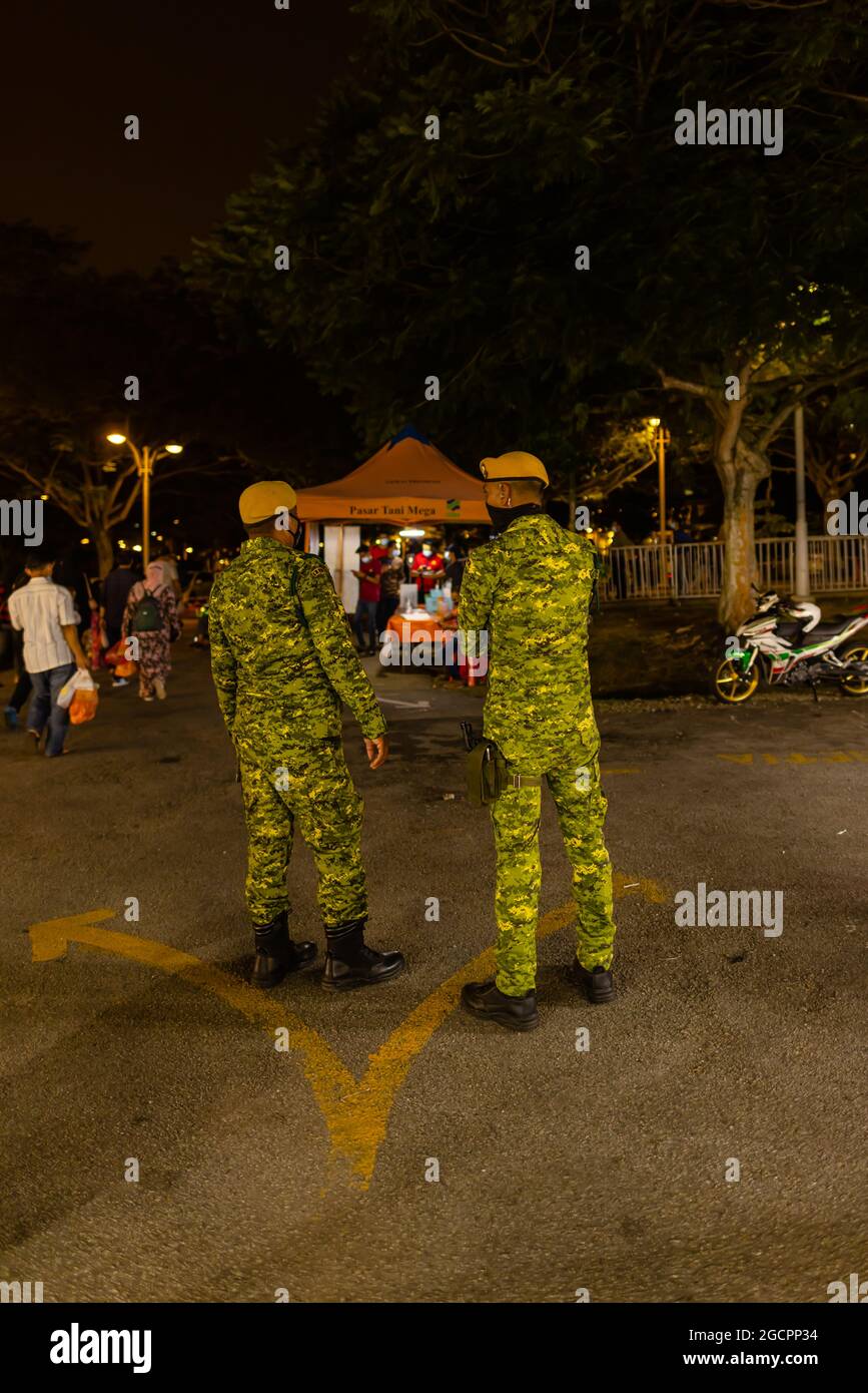 Street food night market at  Putrajaya, near Kuala Lumpur. Security officers monitor compliance with the Corona distance rules. Face masks compulsory Stock Photo